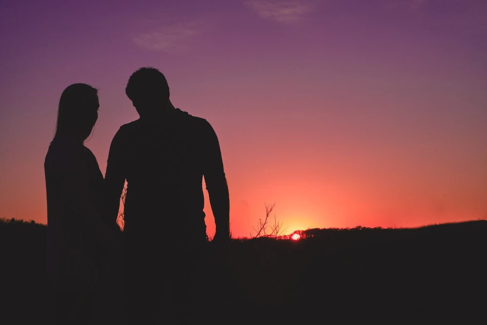 Adirondack Photography A Silhouette Of A Man And Woman Standing In A Field With A Sunset