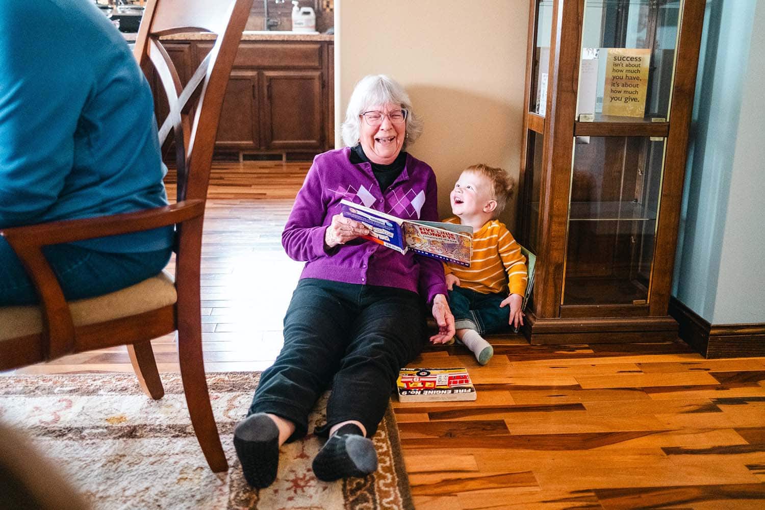 Adirondack Photography A Woman And A Child Sitting On The Floor Reading A Book