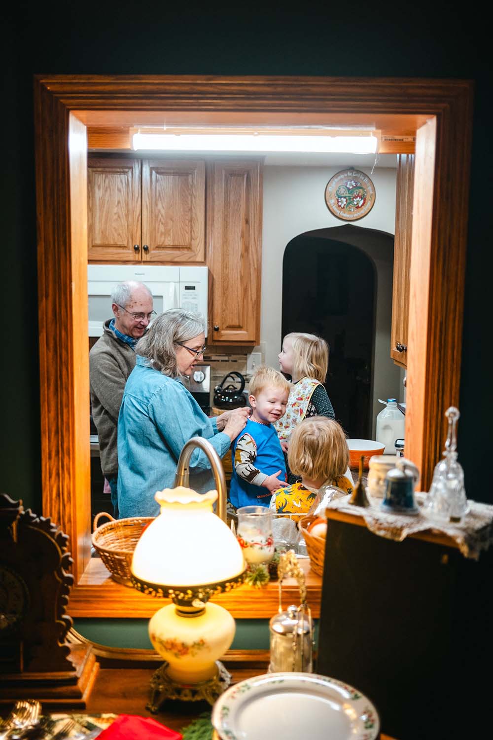 Adirondack Photography A Family Is Gathered Around A Kitchen Table In A Mirror For A Family Photoshoot